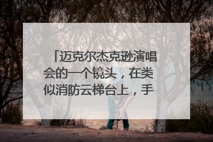 迈克尔杰克逊演唱会的一个镜头，在类似消防云梯台上，手和脚抓住栏杆，